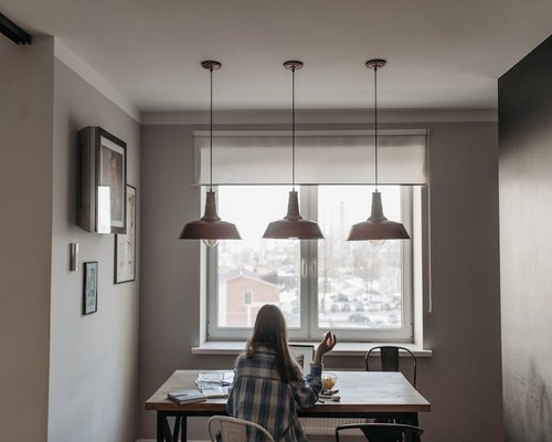 A workspace with natural lighting where someone stands up during a remote meeting