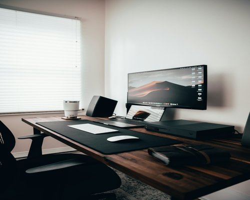 A tidy home office desk setup with an ergonomic posture focus