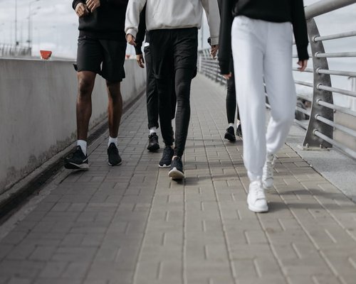 A group of people wearing comfortable shoes walking along a park pathway